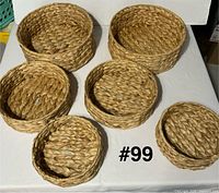 Six round woven baskets displayed on table