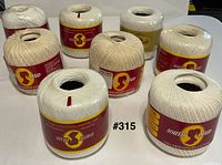 Eight rolls South Maid mercerized cotton crochet thread showing labels and colors