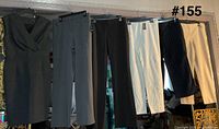 Overall view of dress and five pairs of slacks hanging on rod