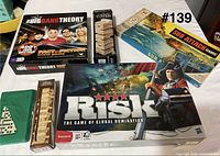 Overview showing all six games: Risk, Big Bang Theory, Sub Attack, dominoes, large and small tumbling tower sets