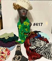 Overview with hats, scarves, belt displayed on table and mannequin