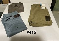All three items folded: khaki shorts, blue shirt with tag, grey shirt