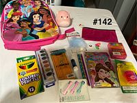 All items spread on table showing backpack, school supplies, plush