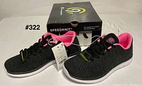 Side view of both sneakers, tags, and original box showing branding