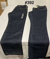 Two pairs of dark wash jeans laid flat side by side