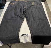Full front view of the jeans laid flat showing color, style and overall condition