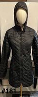 Front view of black quilted hooded jacket on mannequin
