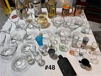 Full assortment of martini, shot, rocks glasses, hip flask and jigger on table