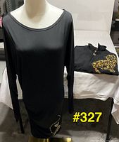 Black long sleeve dress on mannequin, rhinestone swirl detail visible
