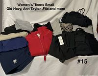 Pile showing most garments including Fila shorts, hoodie, tops, trousers