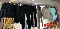 Assorted clothing hanging; eight garments visible