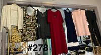 Full view of all seven garments hanging on rack