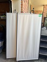Two canvas-covered panels with black metal frames, standing upright