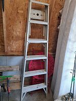 Full view of folded aluminum ladder showing 5 steps and overall wear