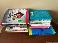 Overview of two stacks of cookbooks and recipe binder
