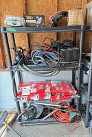 Full view of black plastic four-tier shelving unit with various items stored (not included)