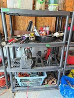 Front view of black plastic 4-shelf unit with items on shelves