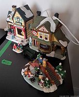 Overall lot showing two buildings, figurines, bench and bridge scene