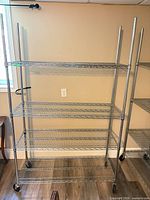 Full view of chrome wire shelving rack showing four shelves and casters
