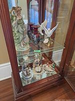Display cabinet showing full assortment of figurines and vases