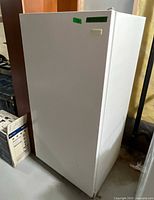 Full front and side view of white upright freezer