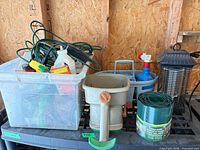 Lot overview showing tote with extension cord, chemicals, edging, caddy, bug zapper, spreader