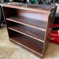 Front view of Gibbard cherry bookcase showing three shelves and plinth base