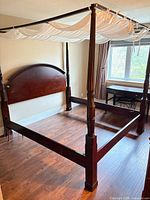 Full view of assembled king four-poster bed frame showing headboard, footboard, posts, canopy rails and side rails