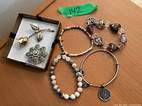 Group shot showing all items: two brooches in box and four bracelets