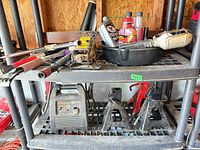 Shelf with jump starter, jack stands, scissor jack, tools and fluids