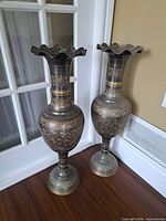 Front view of both tall engraved floor vases beside door