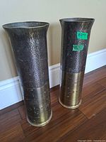 Full view of both hammered brass vases showing height and patina