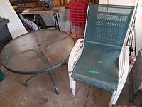 Round glass patio table and one chair side by side