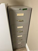 Front view of gray 4-drawer cabinet with label holders and handles