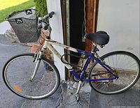 Full left side view of Raleigh hybrid bicycle showing frame, wheels, basket, saddle and U-lock