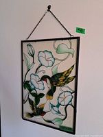 Full view of rectangular stained glass panel hanging by chain