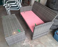 Loveseat with cushion beside coffee table, overall view