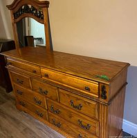 Front view of dresser with attached mirror showing all drawers and pulls