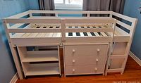 Front view of assembled loft bed showing dresser, bookcase, ladder