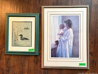 Both framed artworks side by side on wooden floor