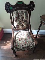 Front view showing carved crest rail, floral upholstery