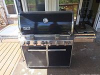 Front view of Weber Summit grill showing burners, controls and doors