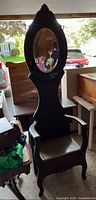 Full front view of wooden hall tree bench showing mirror, hooks, arms, seat