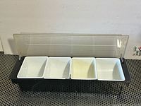 Caddy open showing four white insert trays