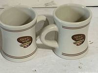 Front view showing both mugs, logos and banding visible