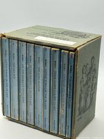 Front view of boxed set showing spines of nine blue hardcovers