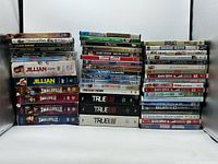 Three stacks of assorted DVD cases showing quantity and variety