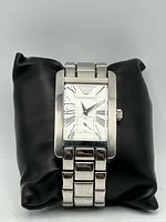 Front view of rectangular stainless-steel watch on cushion