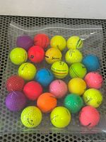 Full view of 25 colourful golf balls in clear zip pouch