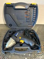 Open case showing impact wrench, sockets, bits and cord